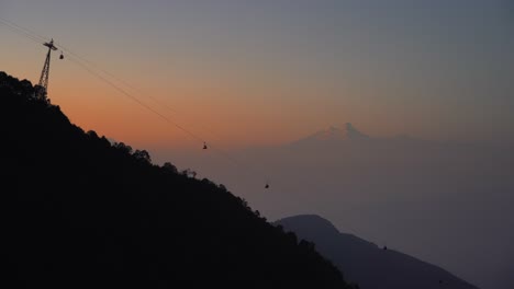puesta de sol sobre las montañas del himalaya con un teleférico en primer plano