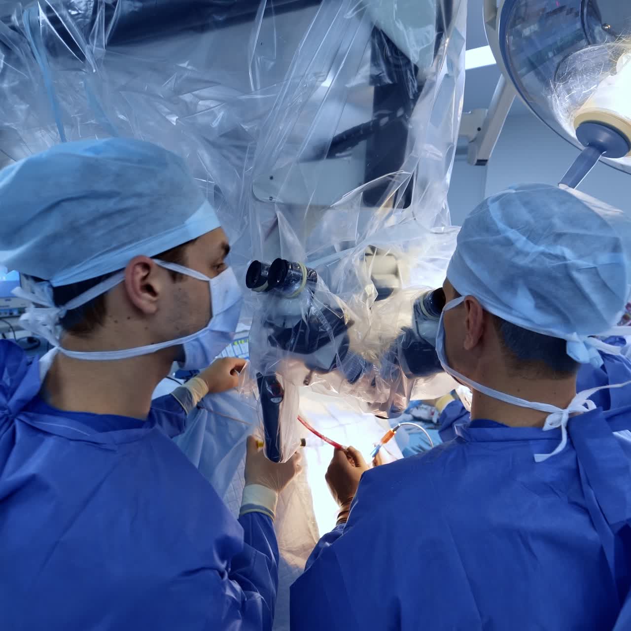 Professional neurosurgeons use advanced microscope conducting surgery. Large medical team working in the modern surgery