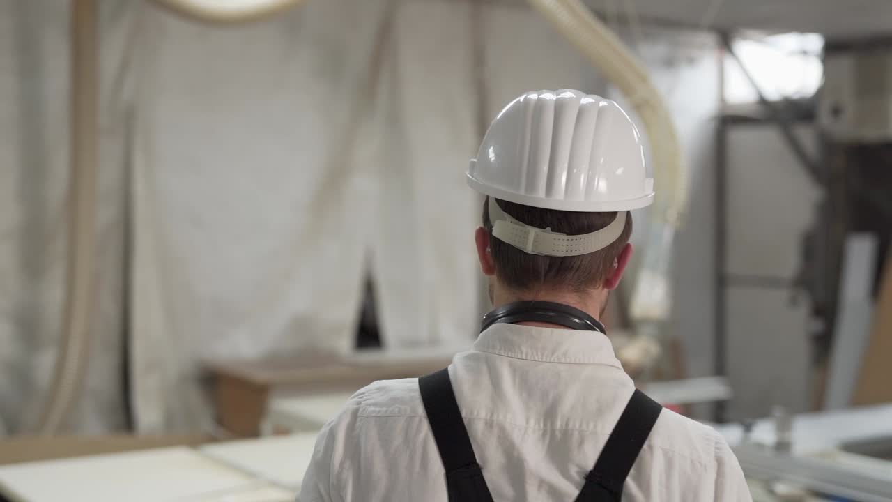 vista trasera de primer plano, el trabajador va y usa casco