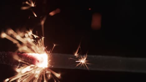 Video-of-close-up-of-sparkler-and-copy-space-on-black-background