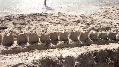 castillo de arena en la playa. olas - piernas para caminar