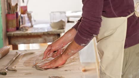 Male-potter-working-on-clay-in-pottery-workshop