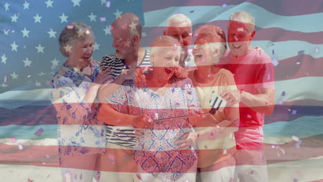 animation of flag of usa over caucasian senior friends on beach in summer