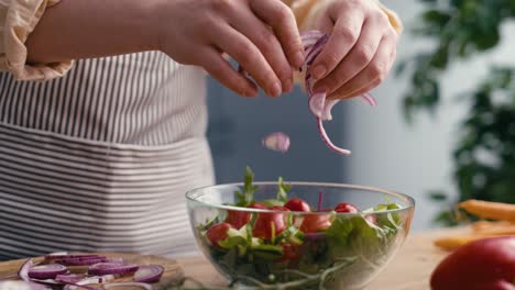 Nahaufnahme-Einer-Frau,-Die-In-Der-Küche-Zwiebeln-Für-Den-Salat-Hinzufügt.