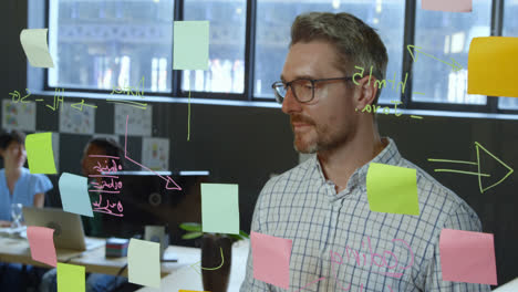 ejecutivo masculino escribiendo en la pared de vidrio en la oficina 4k