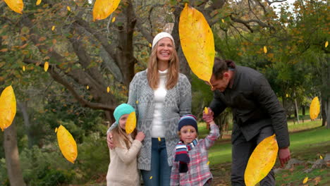 animation of fall leaves falling over happy caucasian family in autumn park