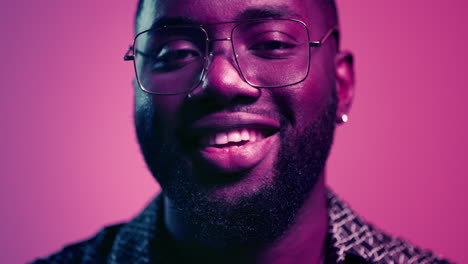 Young-african-man-smiling-in-studio.-Afro-guy-raising-head-up-on-pink-background