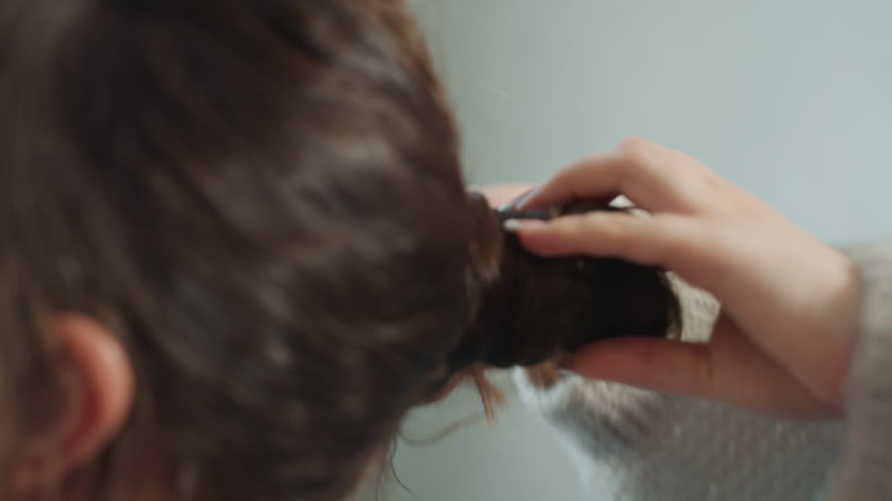 Caucasian Woman Getting Hair Tied, CloseUp Of Sweatered Hands Arranging Brunette Hair Into Low Bun At Nape, Cozy Living Room Vibe, Gentle Movements, Texture Detail And Calm Tutorial Tone
