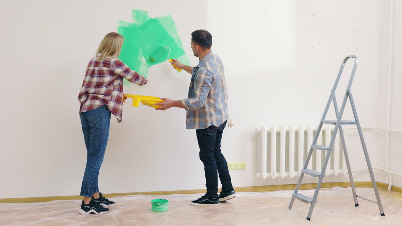 Couple Painting a Wall Green