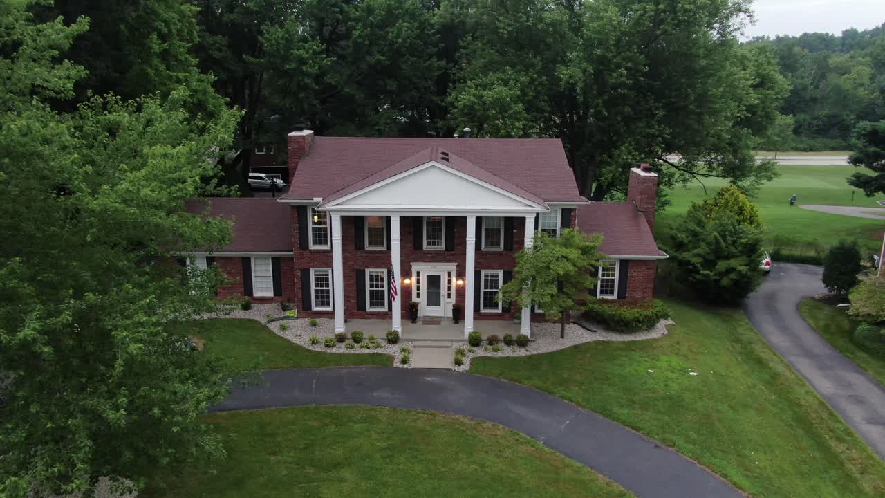 Aerial Drone Footage Pulling Away from a Large House in a Luxury Neighborhood at Dusk