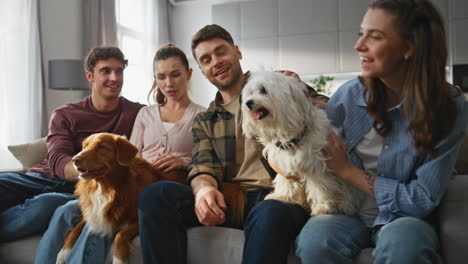 positive people stroking dogs at weekend home. happy owners relaxing on couch