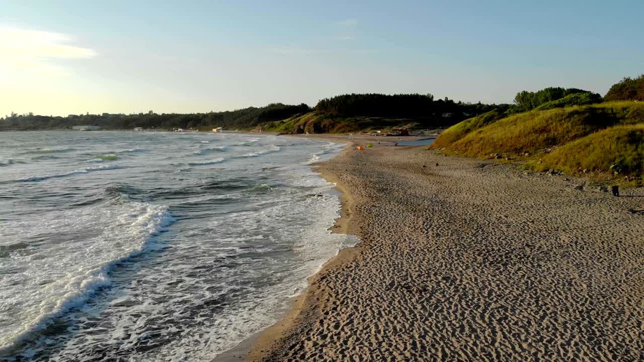 Waves crashing on sand at sunrise during vacation at Bulgaria.