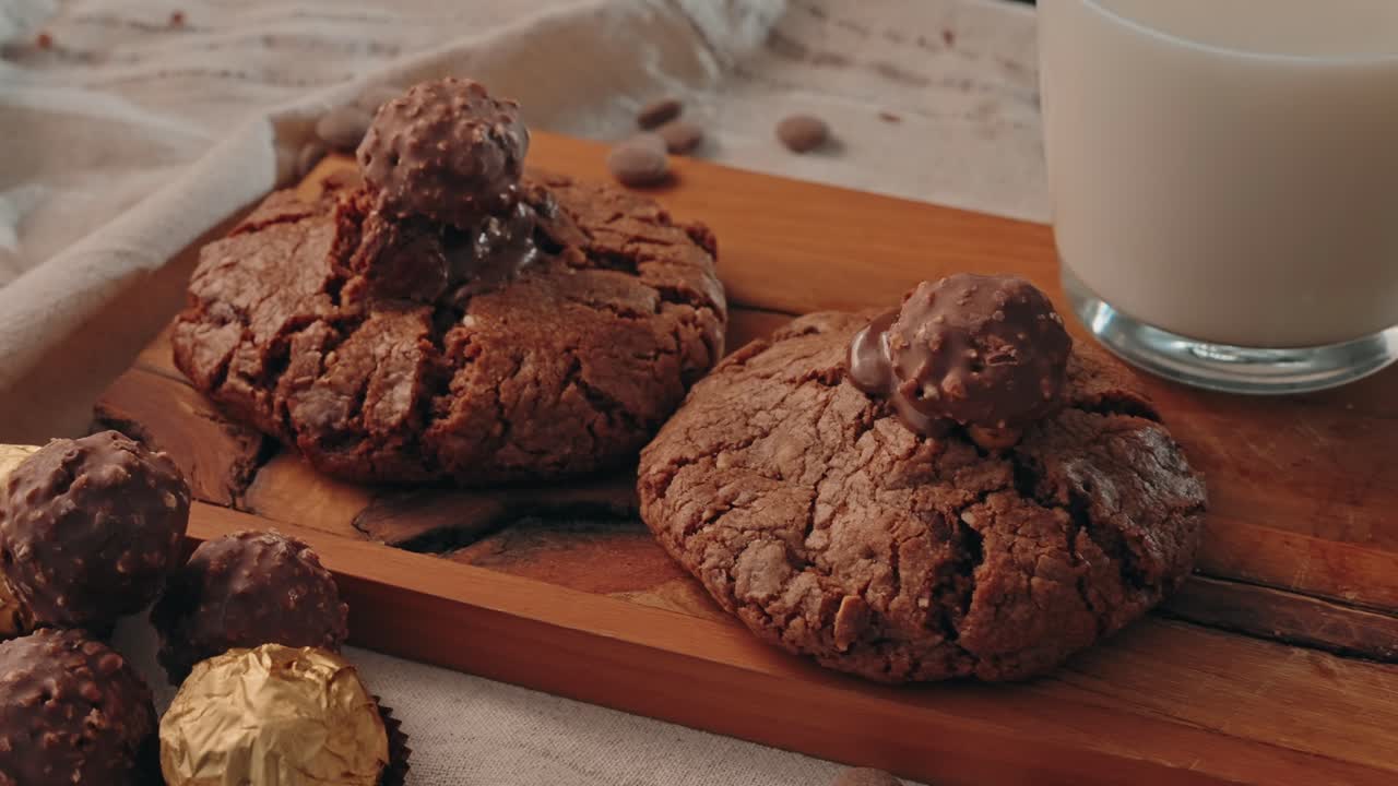 Biscotti al cioccolato appena sfornati serviti con latte su tagliere in legno