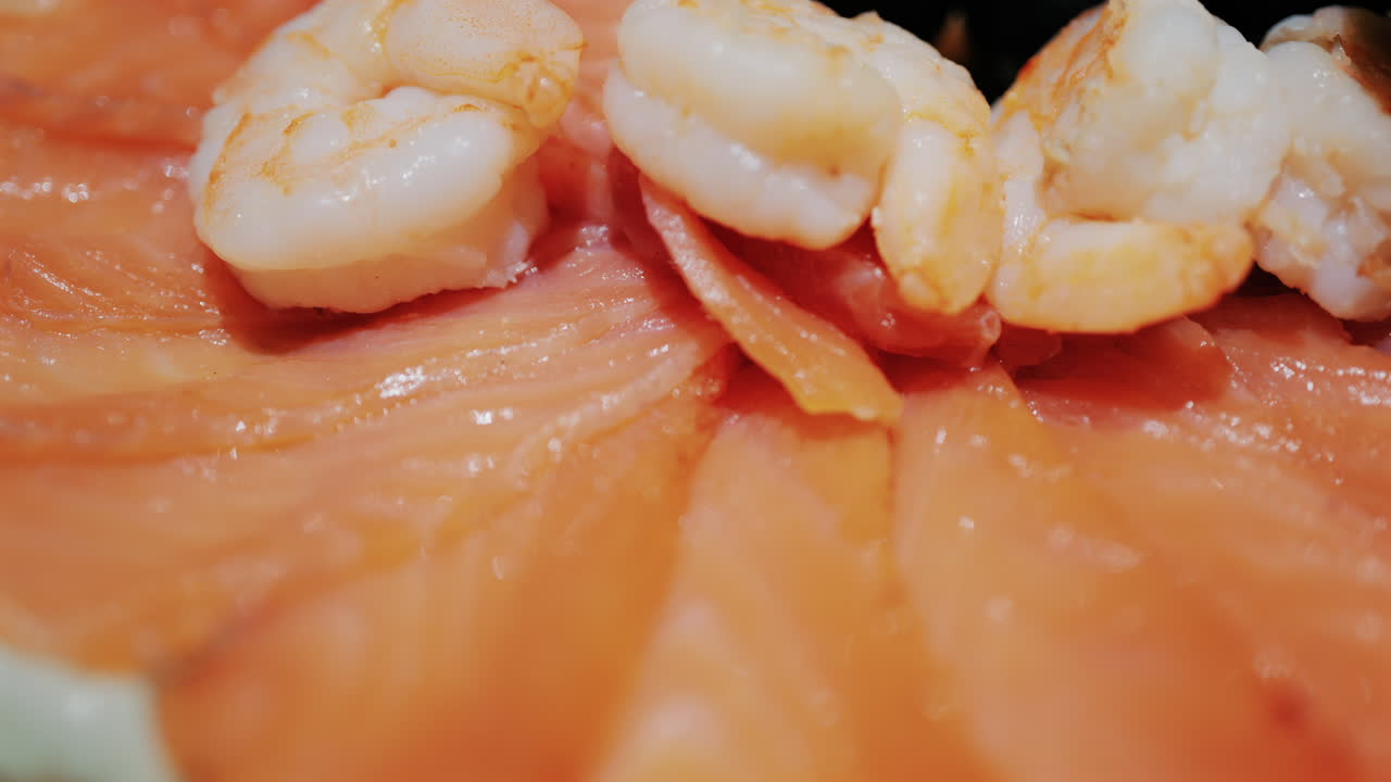 Fresh seafood platter with smoked salmon slices, shrimp, olives, and pate served with lemon and dill garnish