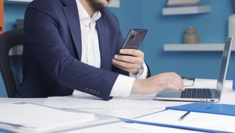 primer plano de un hombre de negocios usando el teléfono en la oficina, dando una marca de verificación a la cámara, diciendo ok.