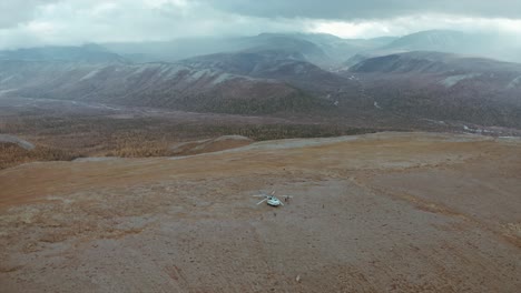 aerial view of a helicopter landing in a mountain valley