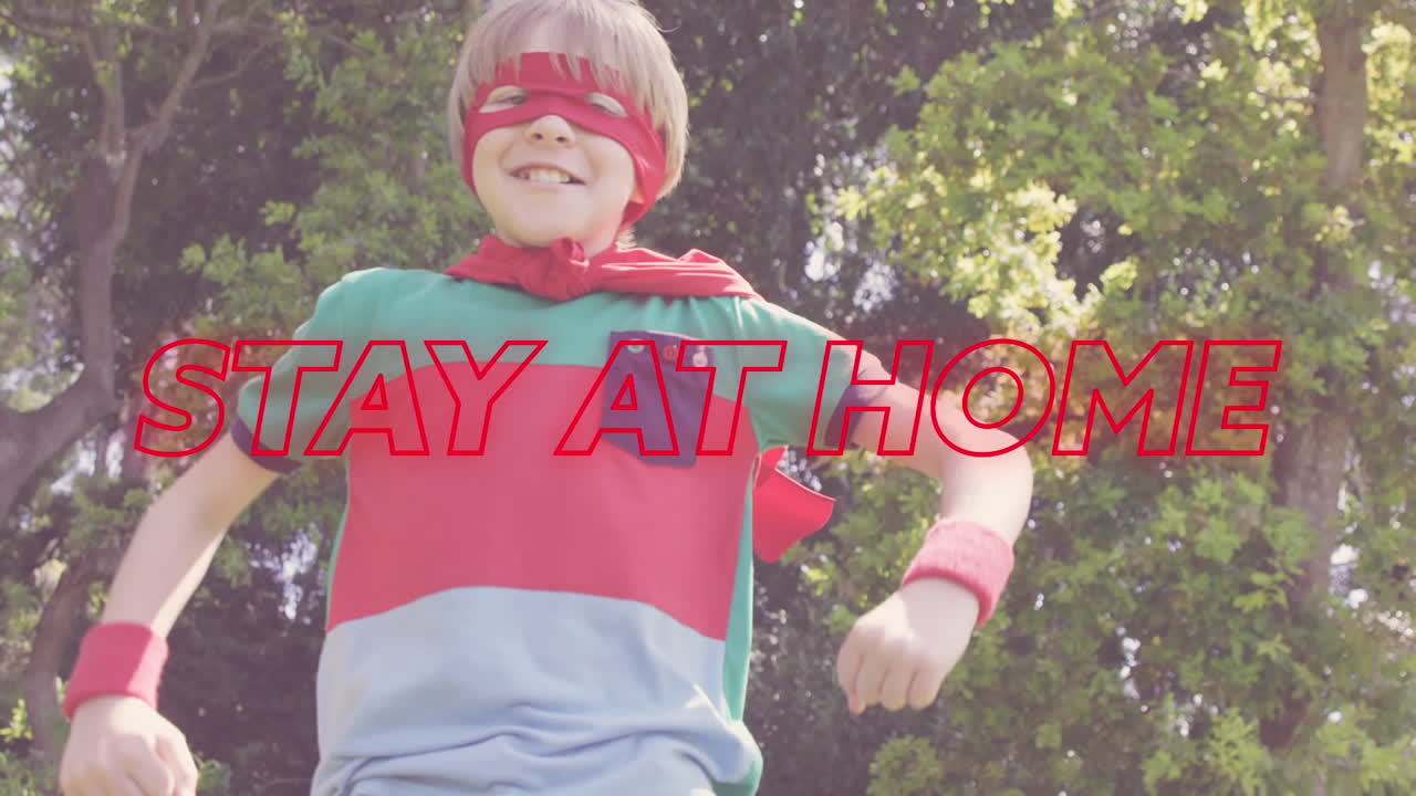 다채로운 네온 단어의 애니메이션 케이프를 입은 백인 소년보다 집에 머물