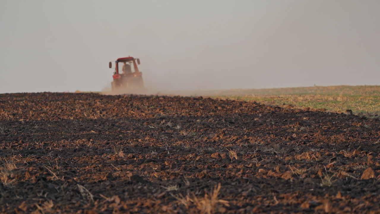 Tractor ploughing a field. Scale farming with tractor and plow in field