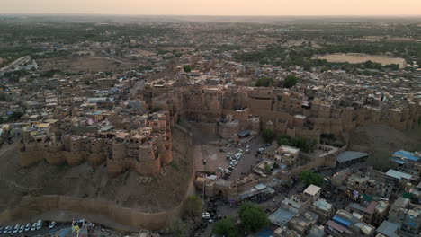 elevating drone footage of the jaisalmer fort cityscape during a golden sunset in rajasthan, india 4k