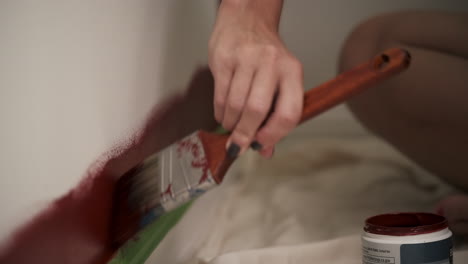 Young-woman-paints-red-wall-in-house