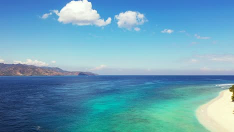 Colores-Vivos-Del-Paisaje-Marino-Panorámico-Con-Mar-Azul-Turquesa,-Arena-Blanca-De-Playa-Exótica-Bajo-Un-Cielo-Brillante-Con-Nubes-Blancas-En-Indonesia