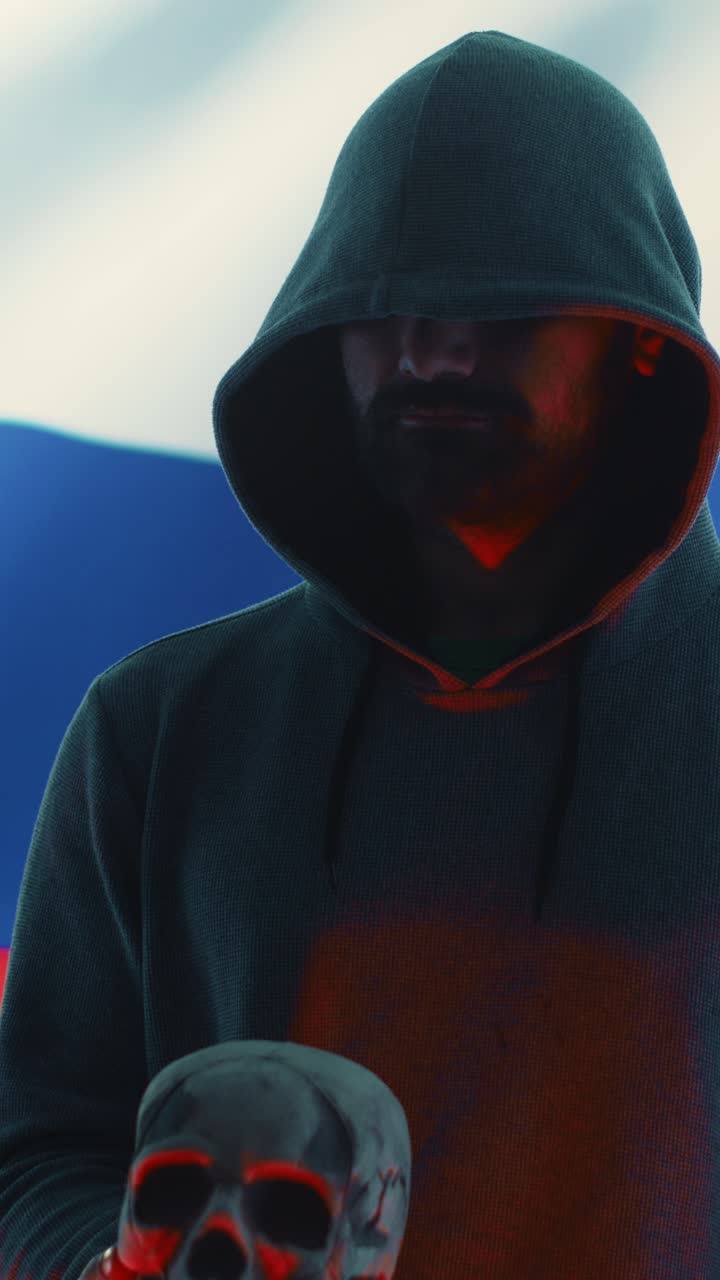 Mysterious Hooded Hacker Holding a Skull with Red Light