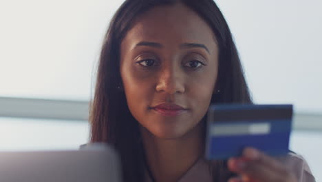 businesswoman working on laptop at desk in office making online payment with credit card