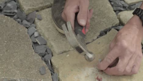 workman hands hammering nails into nail hook cable clip on concrete floor-1