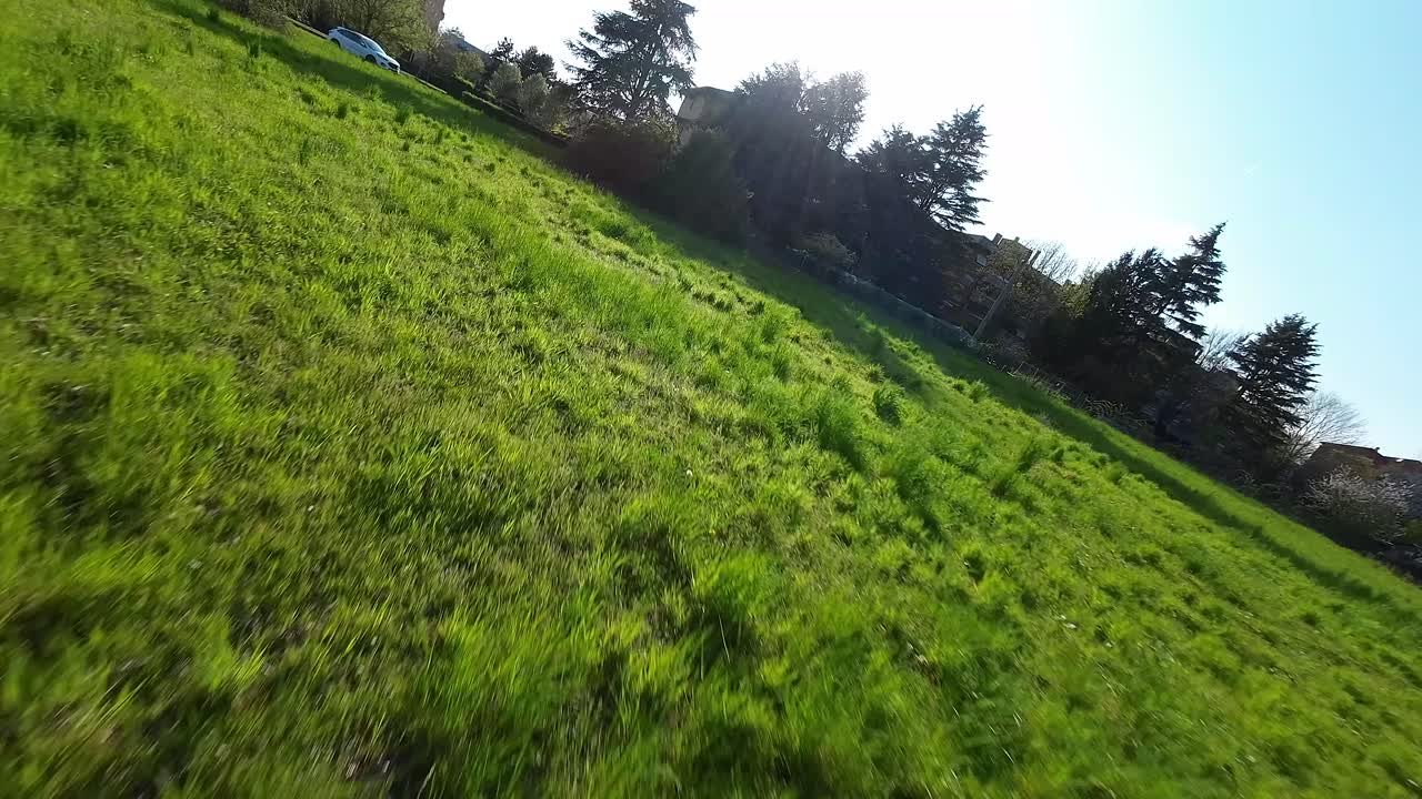 el dron de carreras de fpv despegue y vuela a alta velocidad sobre prados verdes