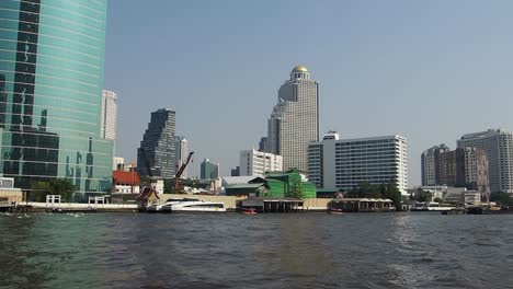 bangkok city view from the boat cruise on river chao phraya in front of icon siam mall - with buildings in front, thailand