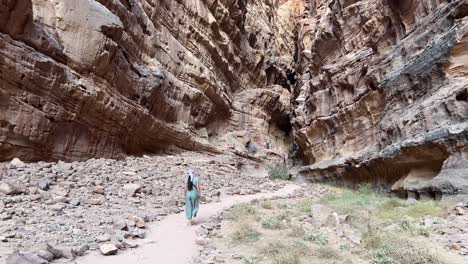 women in wadi rum canyon moving away in jordan