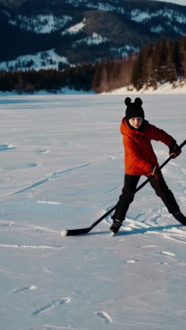 child playing ice hockey on a frozen lake