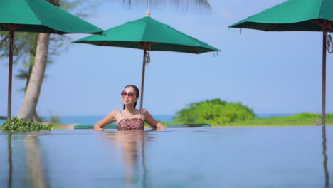 Mujer-Asiática-Sexy-En-La-Piscina-En-Un-Destino-Tropical,-Vista-De-La-Superficie-Del-Agua,-Fotograma-Completo