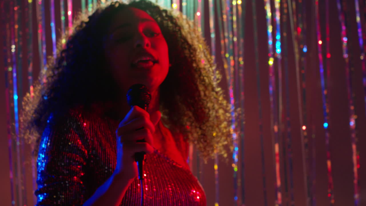 Young Woman With Microphone Singing At Karaoke Nightclub Bar Or Disco With Sparkling Lights In Background 5