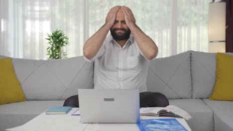 Der-Mann,-Der-Im-Homeoffice-Arbeitet,-Sieht-Sein-Versagen-Auf-Dem-Laptop.