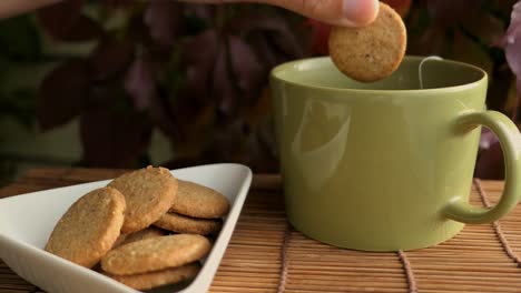 person enjoying cookies and tea on terrace at autumn