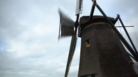molino de viento holandés girando en el viento en un día nublado, tiro lateral todavía