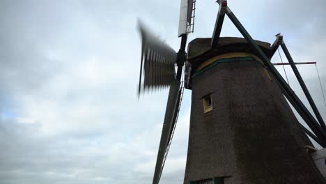 dutch windmill turning in wind on overcast day, side still shot