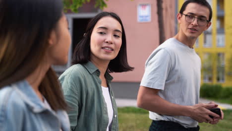 Group-Of-Three-Young-Japanese-Friends-Talking-And-Walking-Together-Outdoors