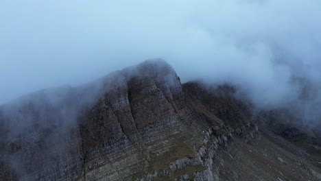 misty clouds surround the rugged pico tortiellas mountain in aragón, spain creating a dramatic view