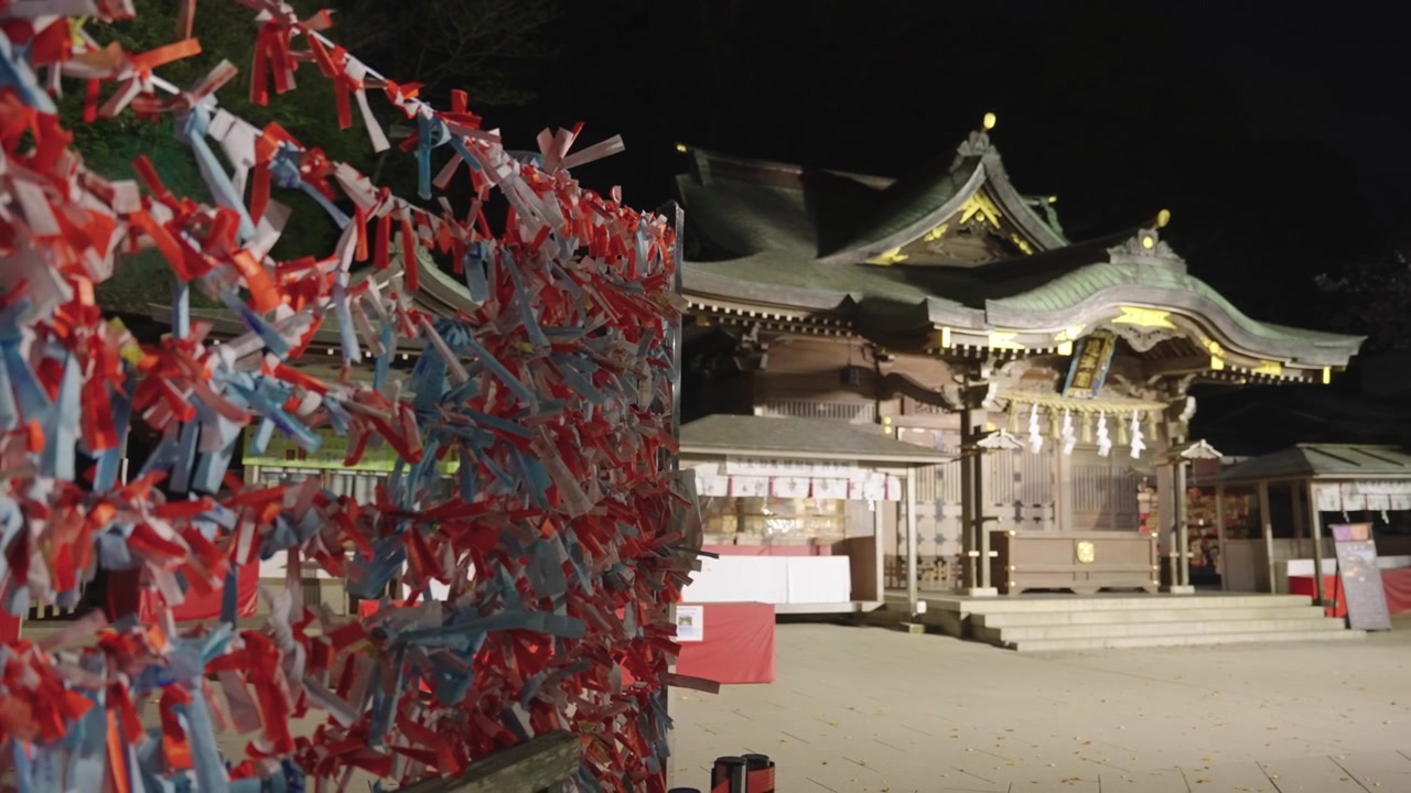 Santuario di Enoshima Hetsumiya, vista notturna con biglietti della fortuna e tempio principale.