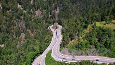 Vista-Aérea-Del-Tráfico-En-Una-Curva-Impresionante-En-Las-Montañas