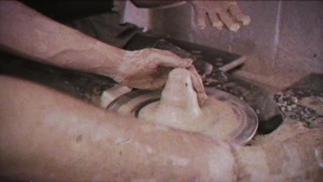 un alfarero enseña a una mujer a hacer platos de arcilla. un hombre toma las manos de una mujer. efecto vintage.