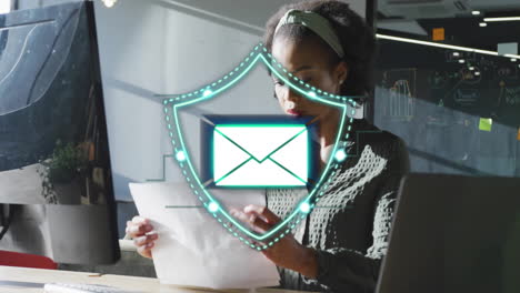 reading documents at desk, woman with email security animation over her