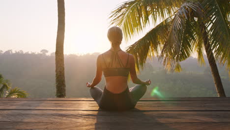 yoga-woman-meditating-at-sunrise-practicing-mindfulness-meditation-exercise-sitting-on-deck-outdoors-in-nature-4k