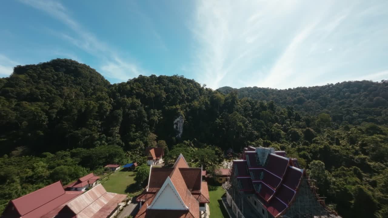 FPV footage provides a captivating establishing shot of a Wat Thai temple, featuring an intricate statue, highlighting the temple's architectural beauty and cultural significance