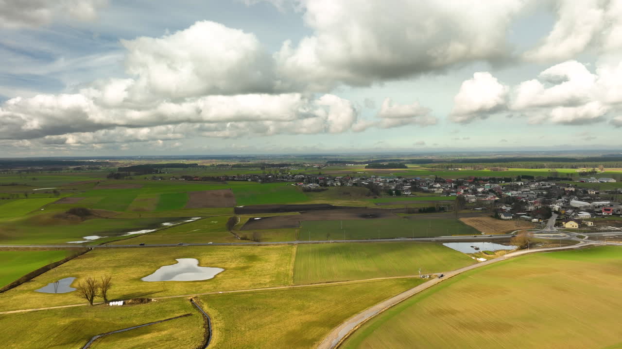 Luchtfoto van sereen landelijk boerenland met witte wolken erboven.