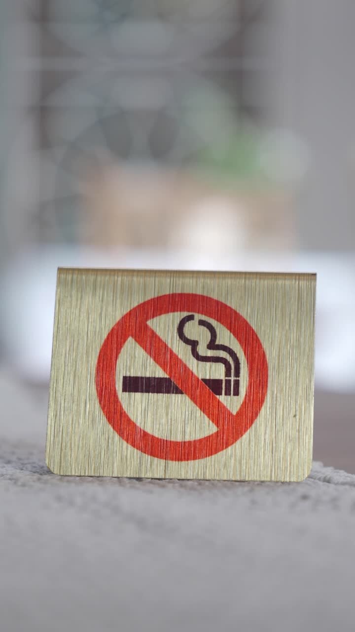 Primo piano di un cartello dorato di divieto di fumo