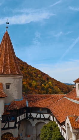 bright tiled rooftops of the castle bran in brasov, transylvania, romania. beautiful view of medieval building in autumn. vertical video