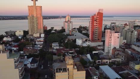 Aerial-drone-shot-of-city-skyline-at-sunset-of-Posadas,-Misiones,-Argentina